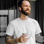 bearded-european-man-drinking-coffee-while-using-m-2021-12-15-13-50-18-utc